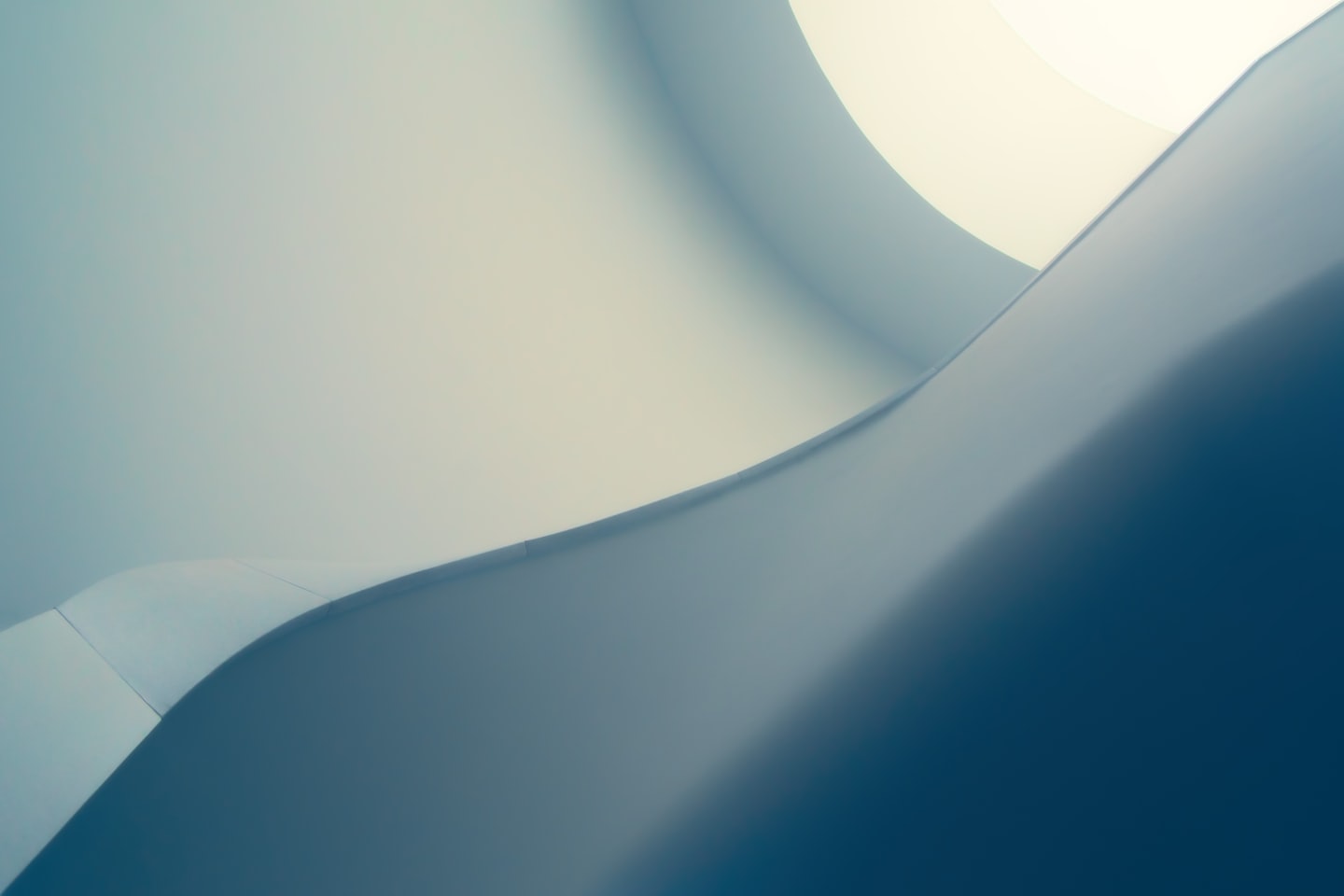 Forme architettoniche morbide e curve in blu-grigio, crema e verde acqua tenui.